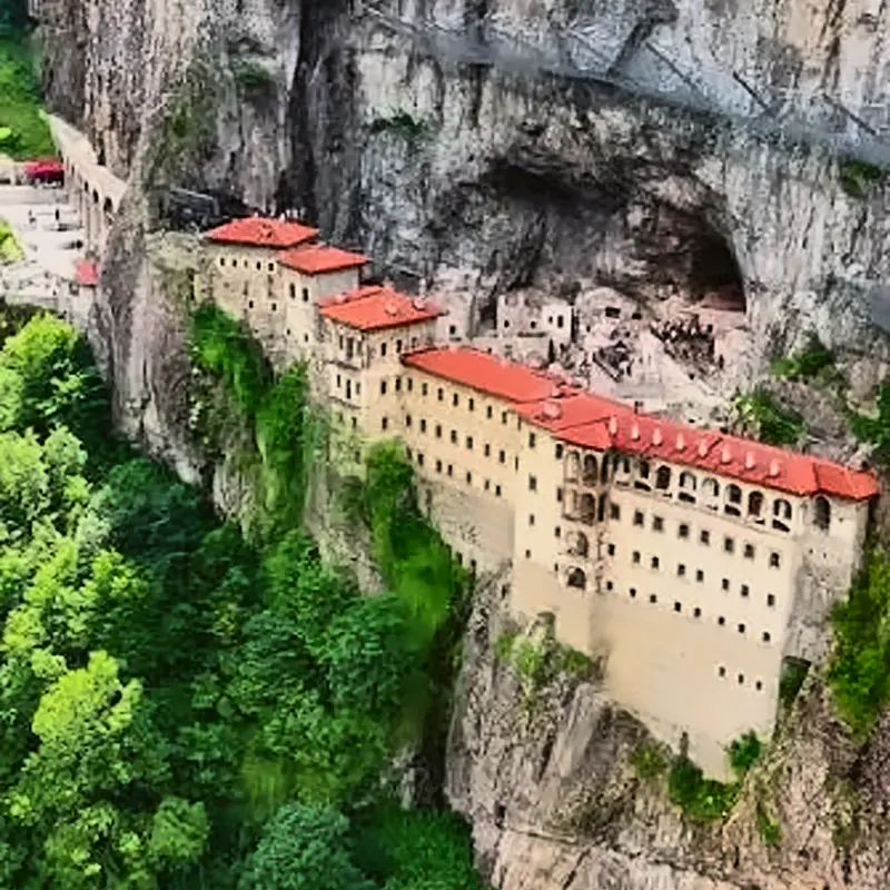 Sumela Monastery hanging on a sheer cliff above a green forest in Altındere Valley